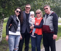 Four adults and a baby all wearing sunglasses in park